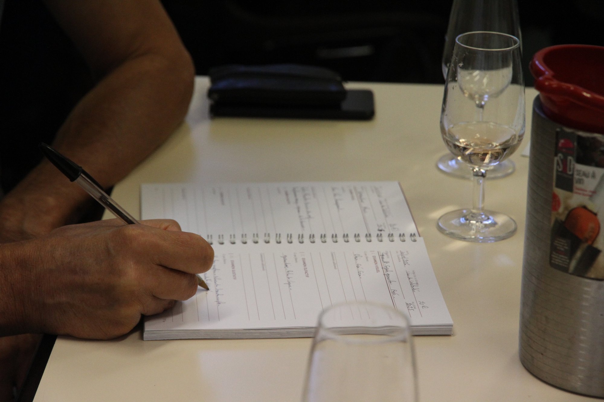Prise de notes dans le carnet de dégustation du club Red Red Wine